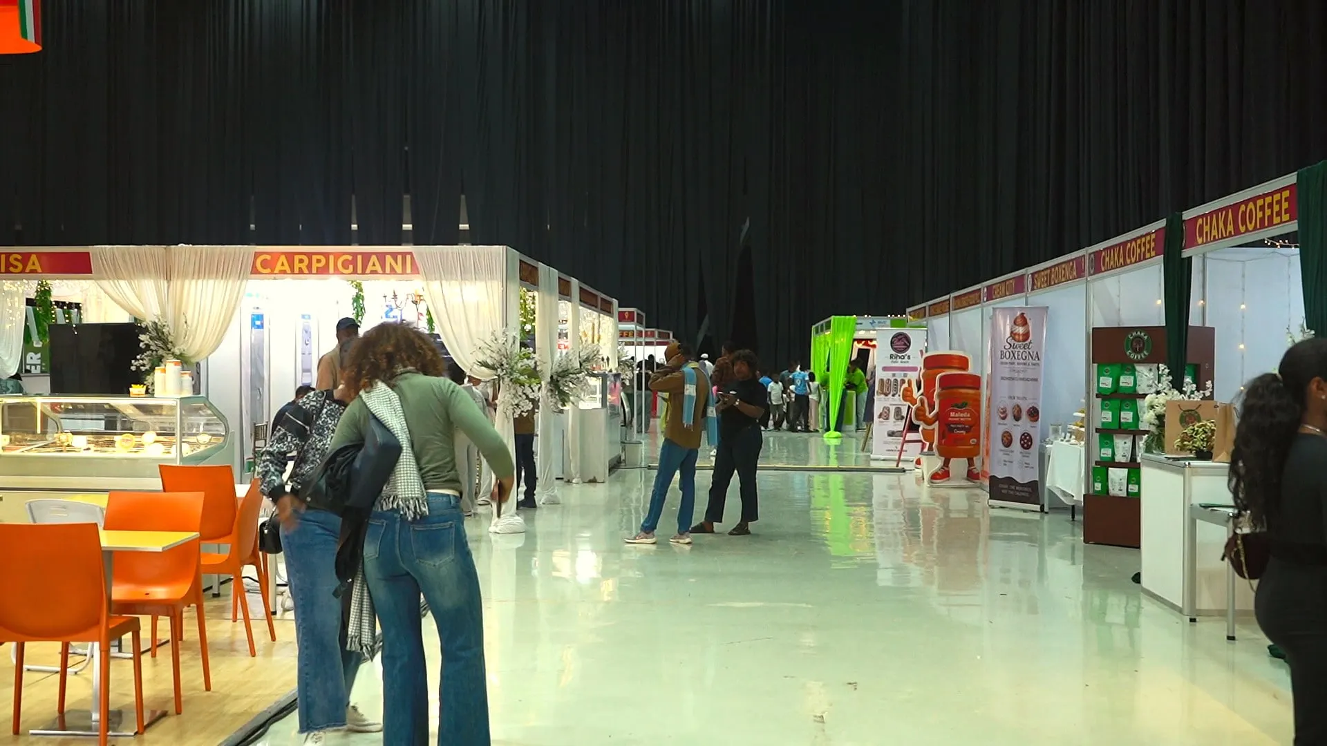 Visitors walking down an aisle of booths
